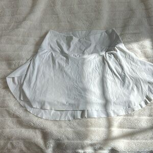White athletic tennis skirt with built-in spandex and pocket with cross waste